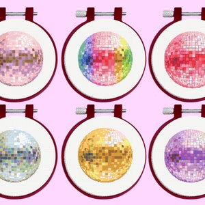 May include: Six round embroidery hoops with different colored disco ball designs. The hoops are white with a red wooden frame.