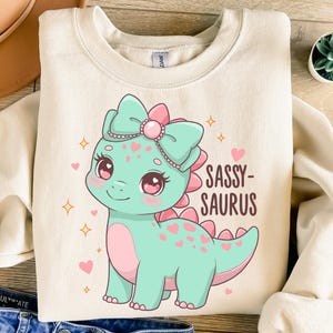 Freche Dinosaurier PNG, süßes Pastell Dino-Mädchen mit Schleife, freche Saurus Clipart, Kawaii Dino-Kunst für Kinder, Kawaii-Dinosaurier, Kinderzimmer-Dino-Druck