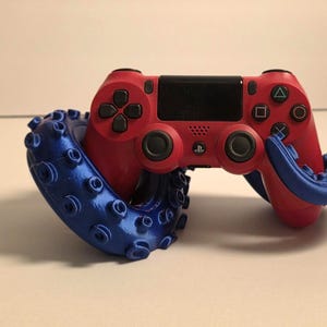 May include: A red PlayStation 4 controller is held in place by a blue 3D printed octopus stand.