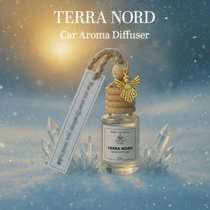 May include: A clear glass car aroma diffuser with a wooden cap and a gold angel charm. The label reads "TERRA NORD Aroma Diffuser". A white tag with text hangs from the top. The background is a snowy scene.