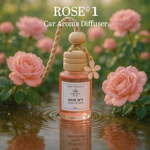 May include: A car aroma diffuser labelled "ROSE Nº1" with a pink liquid, wooden cap, and flower charm. The text "Car Aroma Diffuser" is above the product. The background features pink roses and water.
