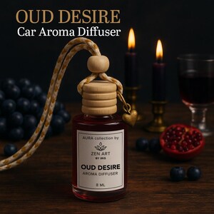 May include: A car aroma diffuser with the text "OUD DESIRE" and "Car Aroma Diffuser". The glass bottle contains a red liquid and has a wooden top. A gold heart charm hangs from the top. The label reads "ZEN ART BY IRIS" and "8 ml".