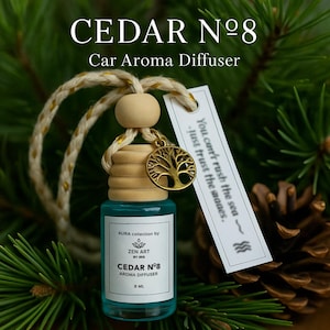 May include: A car aroma diffuser with a teal liquid in a glass bottle. The bottle has a wooden cap and a gold tree charm. The label reads "CEDAR N°8 Aroma Diffuser". A tag with text hangs from the bottle. The bottle contains 8 ml.
