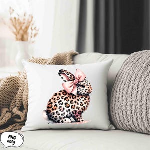 May include: A white pillow with a pink bow and a leopard print bunny rabbit illustration.