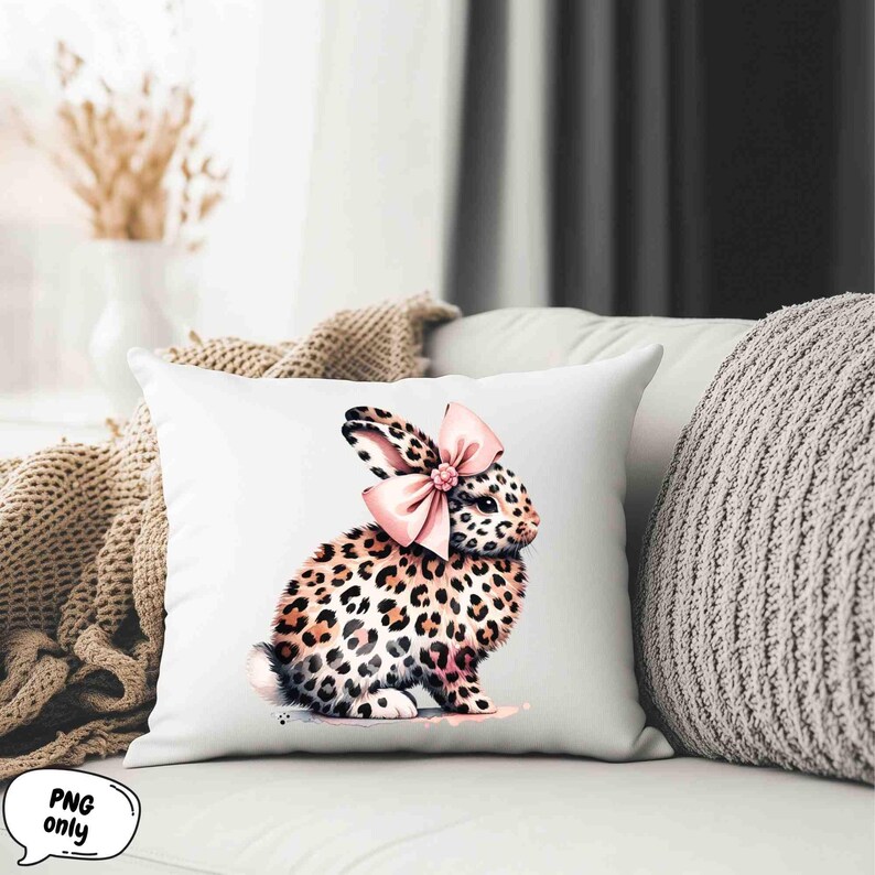May include: A white pillow with a pink bow and a leopard print bunny rabbit illustration.