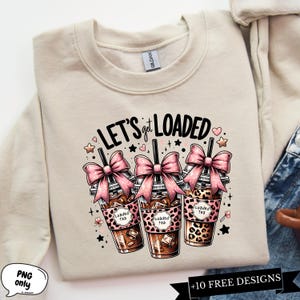 May include: A beige sweatshirt with the text "LET'S get LOADED" in black and pink. Three cartoon illustrations of iced coffee drinks with pink bows and the text "Loaded Tea" are below the text.