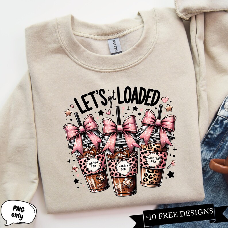 May include: A beige sweatshirt with the text "LET'S get LOADED" in black and pink. Three cartoon illustrations of iced coffee drinks with pink bows and the text "Loaded Tea" are below the text.