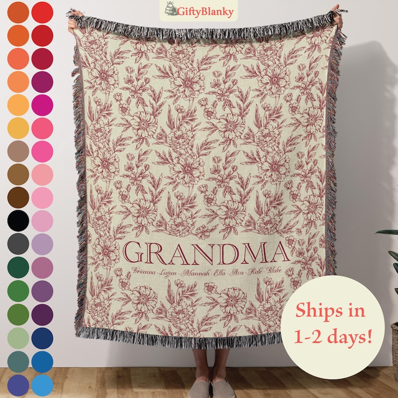 May include: A woven throw blanket with a floral pattern in shades of red and cream. The blanket has a fringe border and the word "Grandma" is printed in red at the bottom. The names "Briana, Logan, Mannah, Ella, Ava, Kole, Blake" are printed in smaller red letters below the word "Grandma".
