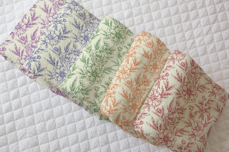 May include: Four fabric swatches with a floral pattern. The swatches are arranged in a stack, with the top swatch being a light pink floral pattern, followed by a green floral pattern, then an orange floral pattern, and finally a red floral pattern.