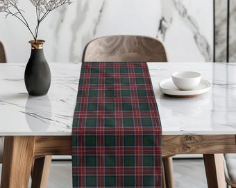 Pode incluir: Um caminho de mesa retangular com um padrão xadrez clássico em verde floresta profundo, azul marinho e linhas brancas finas cruzadas por listras vermelhas vibrantes. O tecido está estendido, exibindo um design de grade repetitivo.