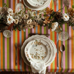 Modern party table setup featuring a multicolor striped table linen. The lively design enhances celebrations and joyful moments. Perfect for birthdays and special events.