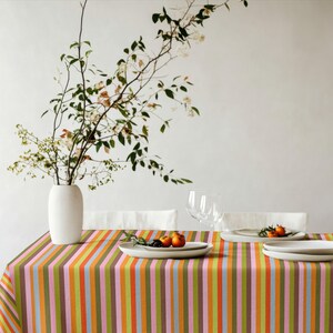 Bold striped tablecloth designed to elevate festive table settings. The colorful stripes bring warmth and personality. Suitable for entertaining guests and hosting events.