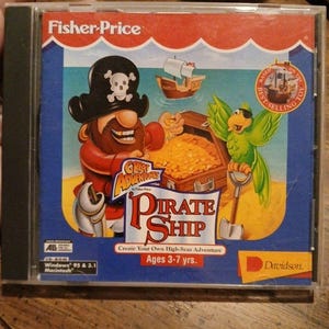 May include: A Fisher-Price Great Adventures Pirate Ship CD-ROM game case for Windows 95, 3.1, and Macintosh. The cover features a cartoon pirate, a green parrot, a treasure chest, and a ship, with the text Ages 3-7 yrs and Davidson.