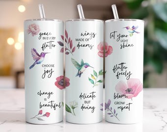 May include: Three white insulated tumblers with straws, each featuring watercolor illustrations of hummingbirds, flowers, and botanical elements. Text includes phrases like "grace in every flutter" and "let your light shine."