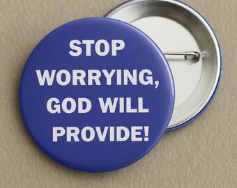 May include: A blue button with the text "STOP WORRYING, GOD WILL PROVIDE!" in white. The button is round with a pin back, and another button is partially visible in the background.