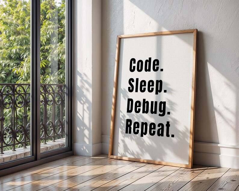 Peut inclure: Une impression encadr&eacute;e avec le texte "Code. Sleep. Debug. Repeat." en lettres noires sur fond blanc. Le cadre est en bois et a une finition brun clair.
