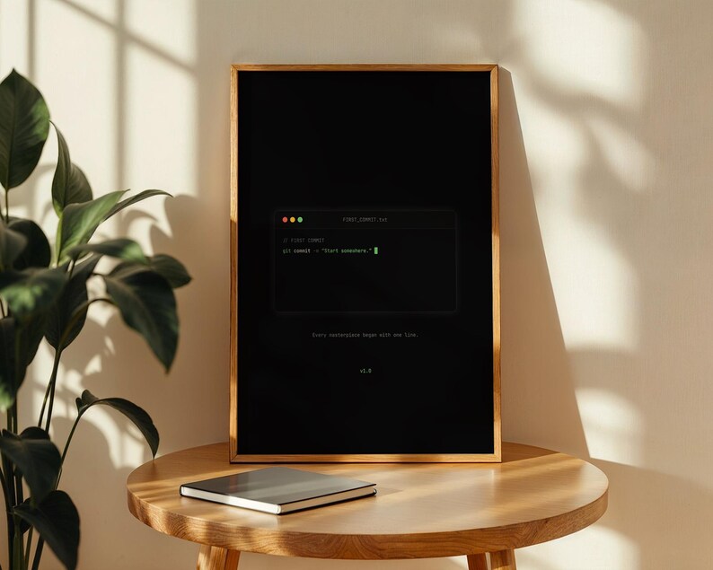 Puede incluir: Una impresi&oacute;n rectangular enmarcada con fondo negro que presenta un gr&aacute;fico de ventana de terminal. El texto dice "git commit -m "Start somewhere."" en verde, con "Every masterpiece began with one line." y "v1.0" en blanco.