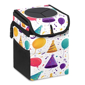 Op de afbeelding: Een witte auto-afvalbak met een zwart deksel en zijkanten, met een kleurrijk patroon van ballonnen, confetti en feesthoeden. De afvalbak heeft een zijvak van gaas en een zwart deksel met een ronde opening.