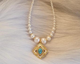 May include: A pearl necklace with a gold pendant. The pendant has a turquoise stone in the center and a white and gold filigree design. The necklace is composed of small, round pearls and larger pearls near the pendant.