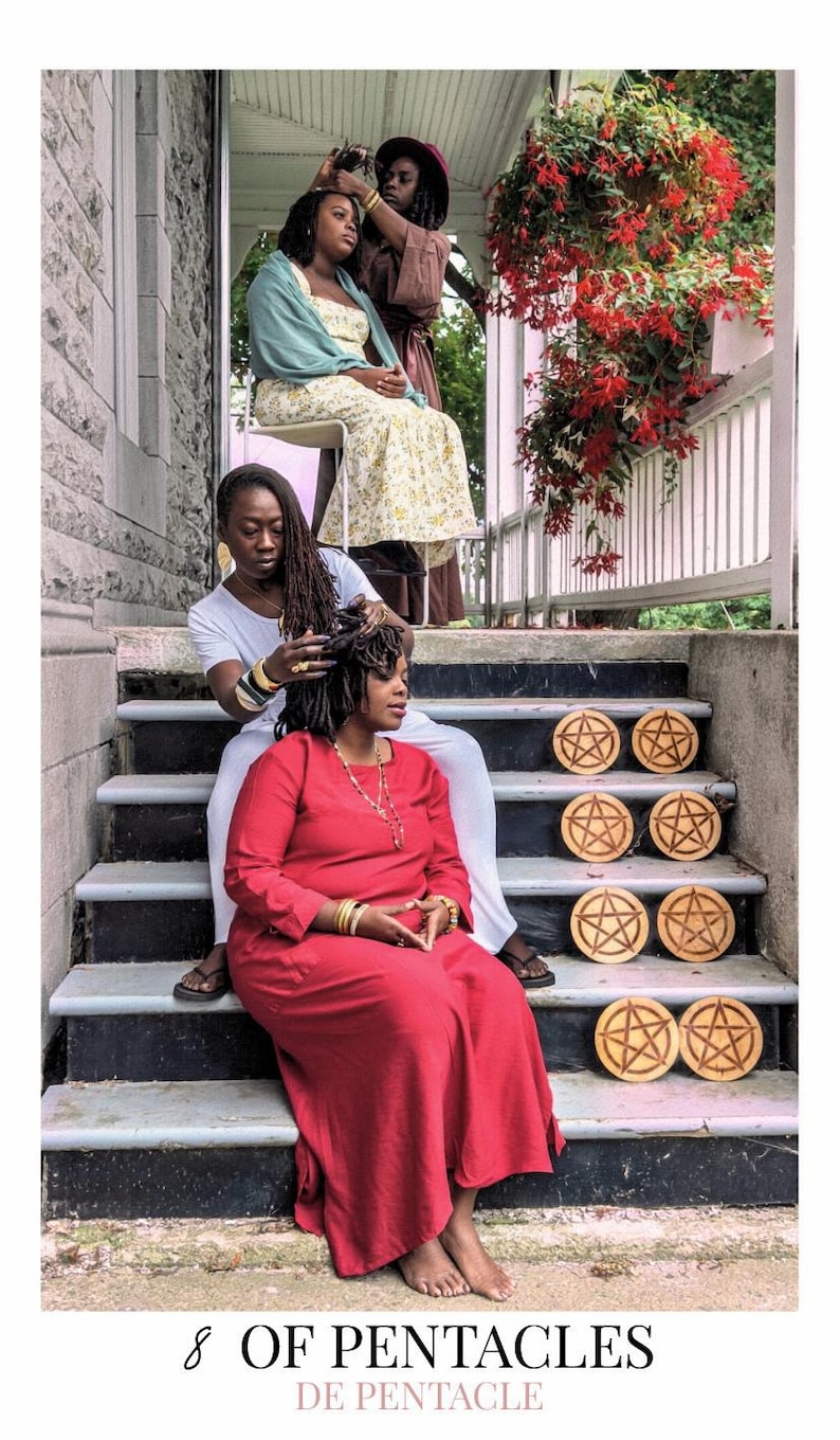 May include: A tarot card titled 8 OF PENTACLES DE PENTACLE featuring four individuals on a porch. One person in a red dress sits on the stairs next to eight circular wooden discs, each engraved with a pentacle symbol. Others are seated nearby.