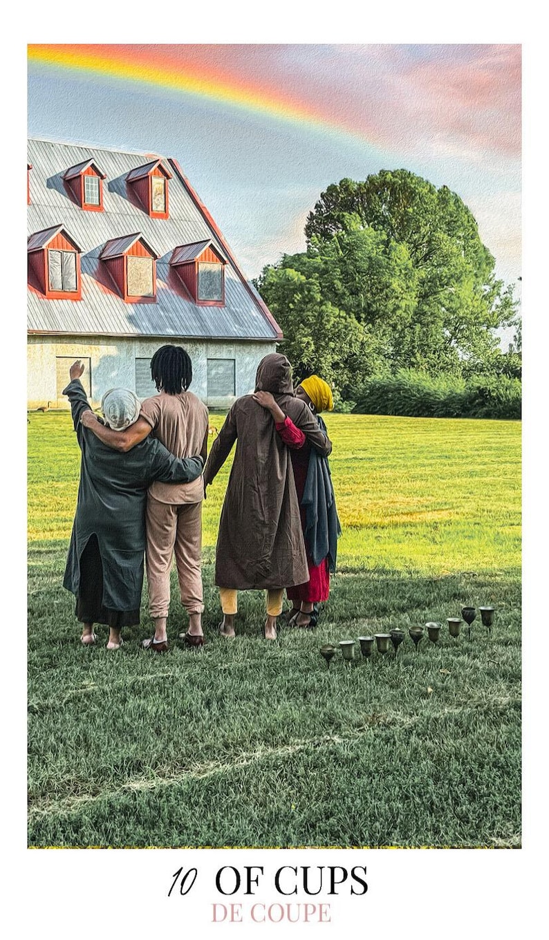 May include: A tarot card titled 10 OF CUPS DE COUPE featuring four people standing in a green field with arms around each other, facing a large building under a rainbow. Ten metallic cups are arranged in an arc on the grass in the foreground.