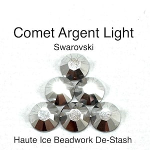 May include: Six silver-colored, round Swarovski crystals arranged in a pyramid shape. Each crystal has a faceted surface and a central, textured design. The text "Comet Argent Light" and "Swarovski" are at the top, and "Haute Ice Beadwork De-Stash" is at the bottom.