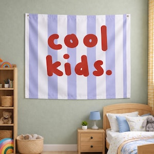 May include: A rectangular wall tapestry featuring vertical light purple and white stripes. The text "cool kids." is printed in the centre in a bold, rounded, red font. The tapestry is secured at the top corners with metal grommets.