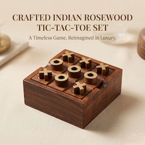 Op de afbeelding: Een vierkante boter-kaas-en-eieren set gemaakt van donkerbruin Indisch rozenhout. Het bord heeft een raster met metalen goudkleurige X- en O-speelstukken. De tekst erboven luidt: CRAFTED INDIAN ROSEWOOD TIC-TAC-TOE SET A Timeless Game, Reimagined in Luxury.