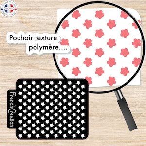 Peut inclure: Un pochoir noir avec un motif répétitif de fleurs blanches. Le pochoir est étiqueté "French Creation". Une loupe montre un gros plan d'un fond blanc avec un motif répétitif de fleurs roses.