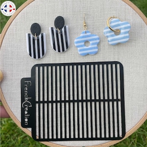 Peut inclure: Trois paires de boucles d'oreilles avec un motif rayé. Les boucles d'oreilles sont en rayures noires et blanches, et en rayures bleu clair et blanches. Les boucles d'oreilles sont présentées sur un fond rayé noir et blanc avec le texte "French Creation".