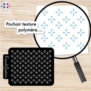 Puede incluir: Una plantilla negra con un patrón repetitivo de pequeñas flores blancas. La plantilla está etiquetada como "Pochoir texture polymère..." y "French Création".
