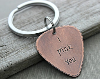 May include: Copper guitar pick keychain with the words "I pick you" engraved on it.
