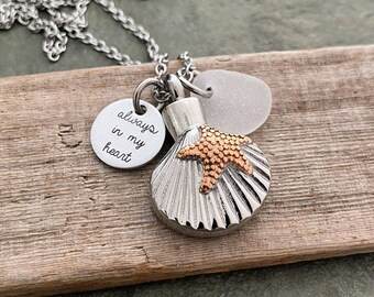 May include: Silver chain necklace with a seashell charm, a small starfish charm, and a round charm with the inscription "always in my heart".
