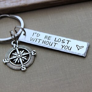 May include: Silver compass keychain with a silver tag that reads "I'd be lost without you" with a hand-drawn heart.