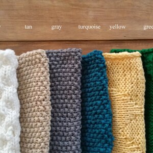 May include: Ten knitted swatches in different colors, including white, ivory, tan, gray, turquoise, yellow, green, and red. The swatches are arranged in a row from left to right.