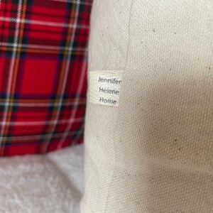 May include: A white canvas pillow with a label that reads "Jennifer Helene Home".