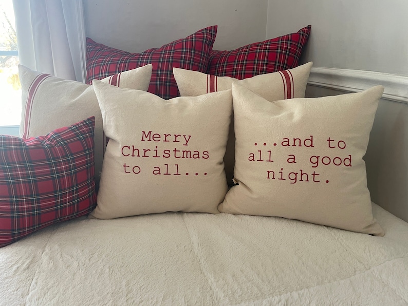 May include: Two cream-colored throw pillows with red embroidered text. The text on the left pillow reads "Merry Christmas to all..." and the text on the right pillow reads "...and to all a good night."