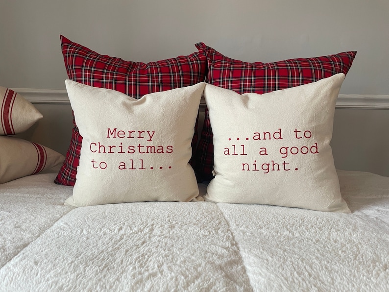 May include: Two white throw pillows with red embroidered text. The pillow on the left reads "Merry Christmas to all..." and the pillow on the right reads "...and to all a good night."