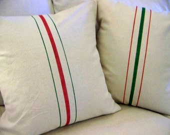 May include: Two white pillowcases with red and green stripes. The pillowcases are made of a soft, natural fabric.