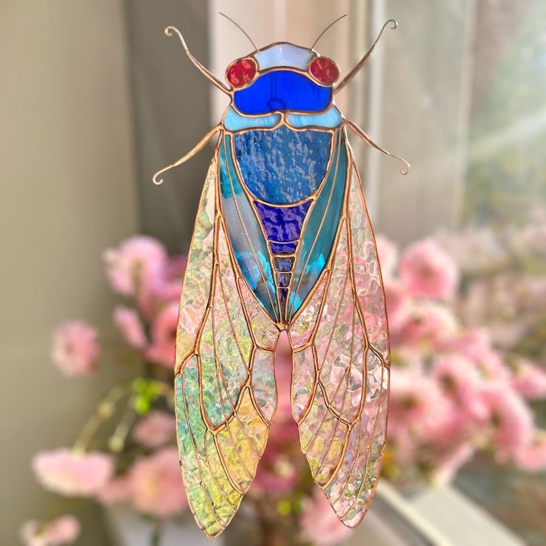 A delicate stained glass cicada with shimmering, iridescent wings that capture and reflect light beautifully – a thoughtful and unique gift.