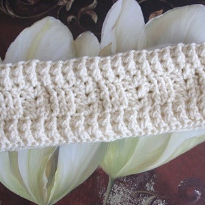 May include: A white crocheted headband with a textured pattern.
