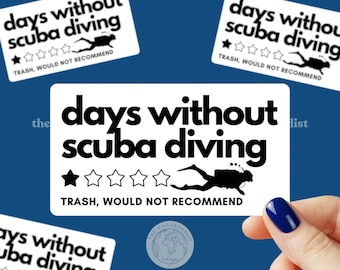 May include: A rectangular white sticker featuring the black text "days without scuba diving" above a row of five stars, with one star filled in black. A black silhouette of a scuba diver is present, and the text "TRASH, WOULD NOT RECOMMEND" is below.