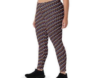 May include: Close-fitting leggings featuring a repeating pattern of white, orange, and purple dots on a dark purple background. The leggings are made of a stretchy material. The person is wearing black trainers.