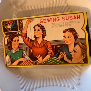 May include: Vintage "Sewing Susan" needle box featuring a retro illustration of women sewing. The box has a yellow border and includes the text "70 Gold Eye Needles with Threader". The artwork depicts women in various outfits, with a floral design in the background.