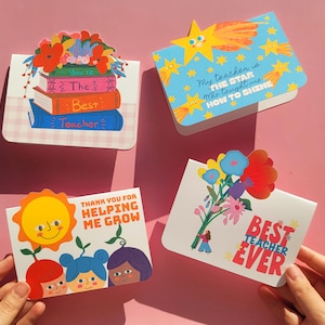 May include: Four colourful greeting cards with teacher appreciation themes. One card features a stack of books with the words "You're The Best Teacher." Another says "My teacher is the star who taught me how to shine." The other two cards say "Thank you for helping me grow" and "Best Teacher Ever."