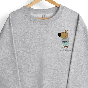 May include: A gray sweatshirt with a cartoon dog wearing blue jeans and the text "Just a chill guy".