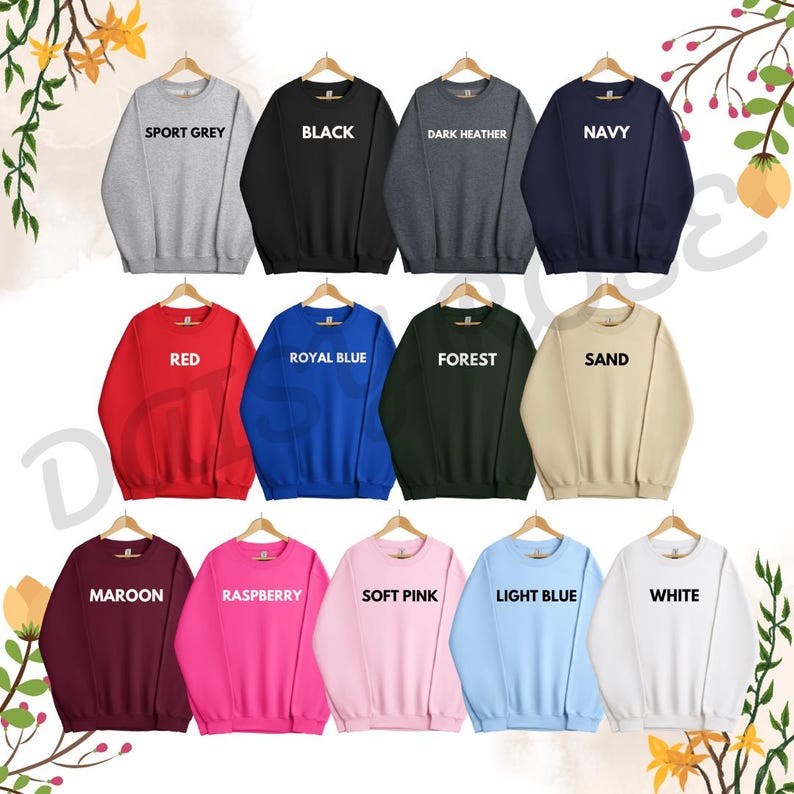 Op de afbeelding: Een selectie van 15 crewneck sweatshirts in verschillende kleuren, waaronder sport grijs, zwart, donker grijs, marineblauw, rood, koninklijk blauw, bosgroen, zand, bordeauxrood, framboos, zacht roze, lichtblauw en wit. Elk sweatshirt heeft een andere kleur en heeft een wit tekstlabel met de kleurnaam.