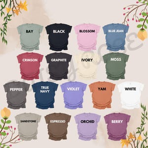 Puede incluir: Una colecci&oacute;n de camisetas de varios colores, cada una con el nombre de su color impreso. Los colores incluyen negro, blanco, azul vaquero, carmes&iacute; y violeta. Las camisetas se muestran sobre un fondo claro con detalles florales.