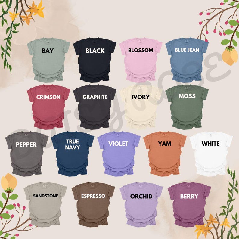 Puede incluir: Una colecci&oacute;n de camisetas de varios colores, cada una con el nombre de su color impreso. Los colores incluyen negro, blanco, azul vaquero, carmes&iacute; y violeta. Las camisetas se muestran sobre un fondo claro con detalles florales.