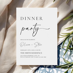 Op de afbeelding: Een witte uitnodigingskaart met zwarte tekst met de tekst "DINNER party" in een stijlvol lettertype. De kaart bevat de namen "Olivia + Steve", datum, tijd en adres voor het evenement. De kaart staat tegen een neutrale stoffen achtergrond.